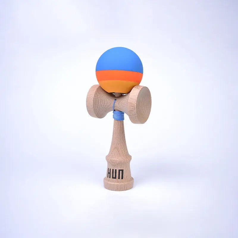 HUN Kendama Kylin Model with a blue, orange, and yellow striped ball, natural wood handle, and light background.