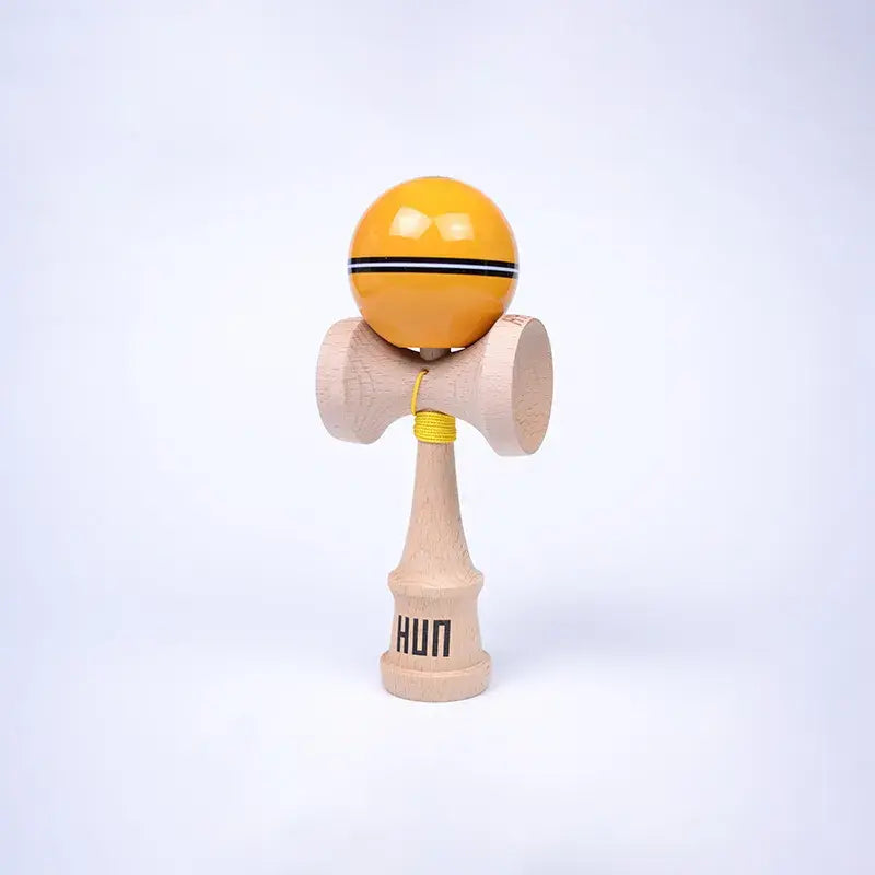HUN Kendama Kylin Model with a glossy yellow ball, black stripe detail, natural wood handle, and light background.