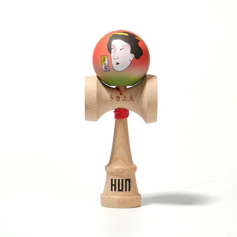 HUN kendama with an illustrated red-green ball, Japanese-style portrait artwork, red string, and natural wood handle, isolated on a light background.