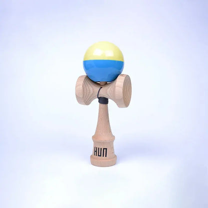 HUN Kendama Kylin Model with a glossy pale yellow and blue ball, natural wood handle, and light background.