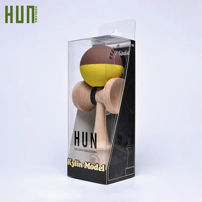 HUN Kendama Kylin Model packaged in a clear retail box, with a wooden kendama and brown-yellow ball on a light background.