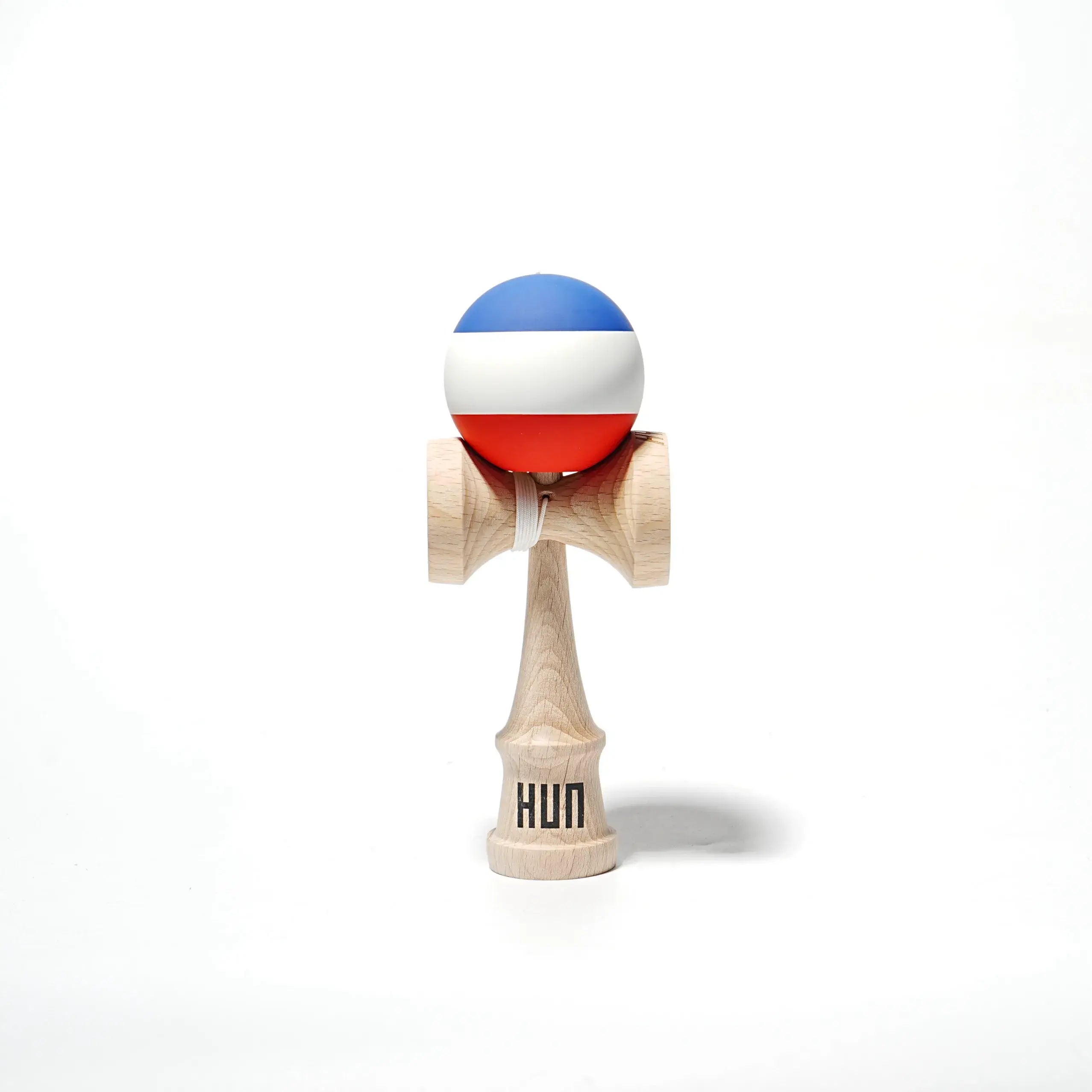 HUN Kendama with a blue, white, and red striped ball, natural wood handle, and light gray background.