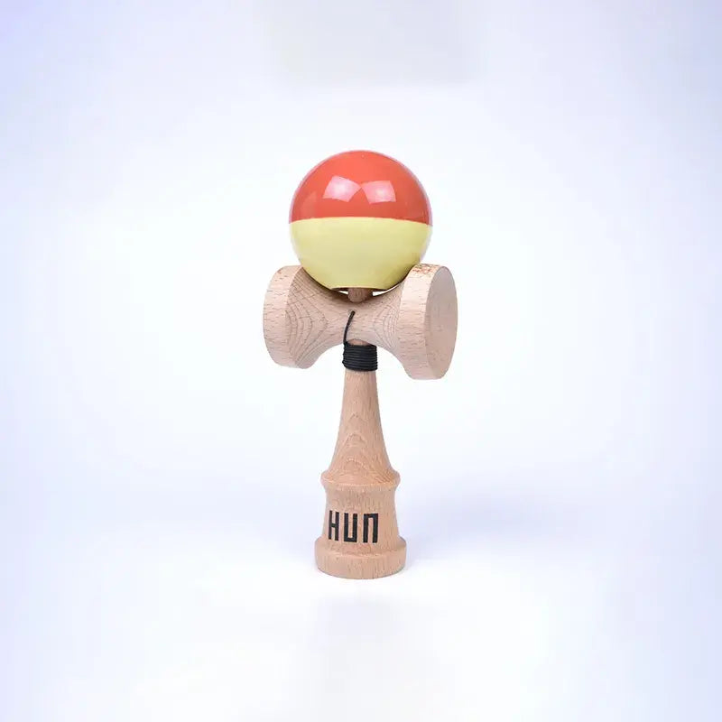 HUN Kendama Kylin Model with a glossy coral and pale yellow ball, natural wood handle, and light background.