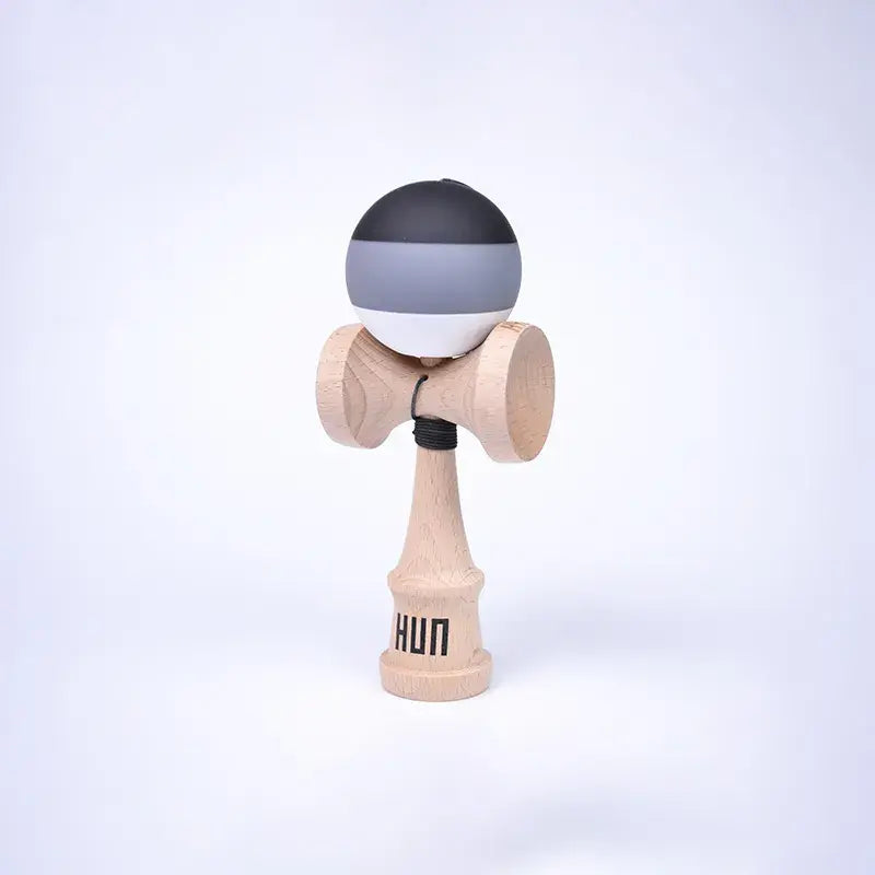 HUN Kendama Kylin Model with a black, gray, and white striped ball, natural wood handle, and light background.