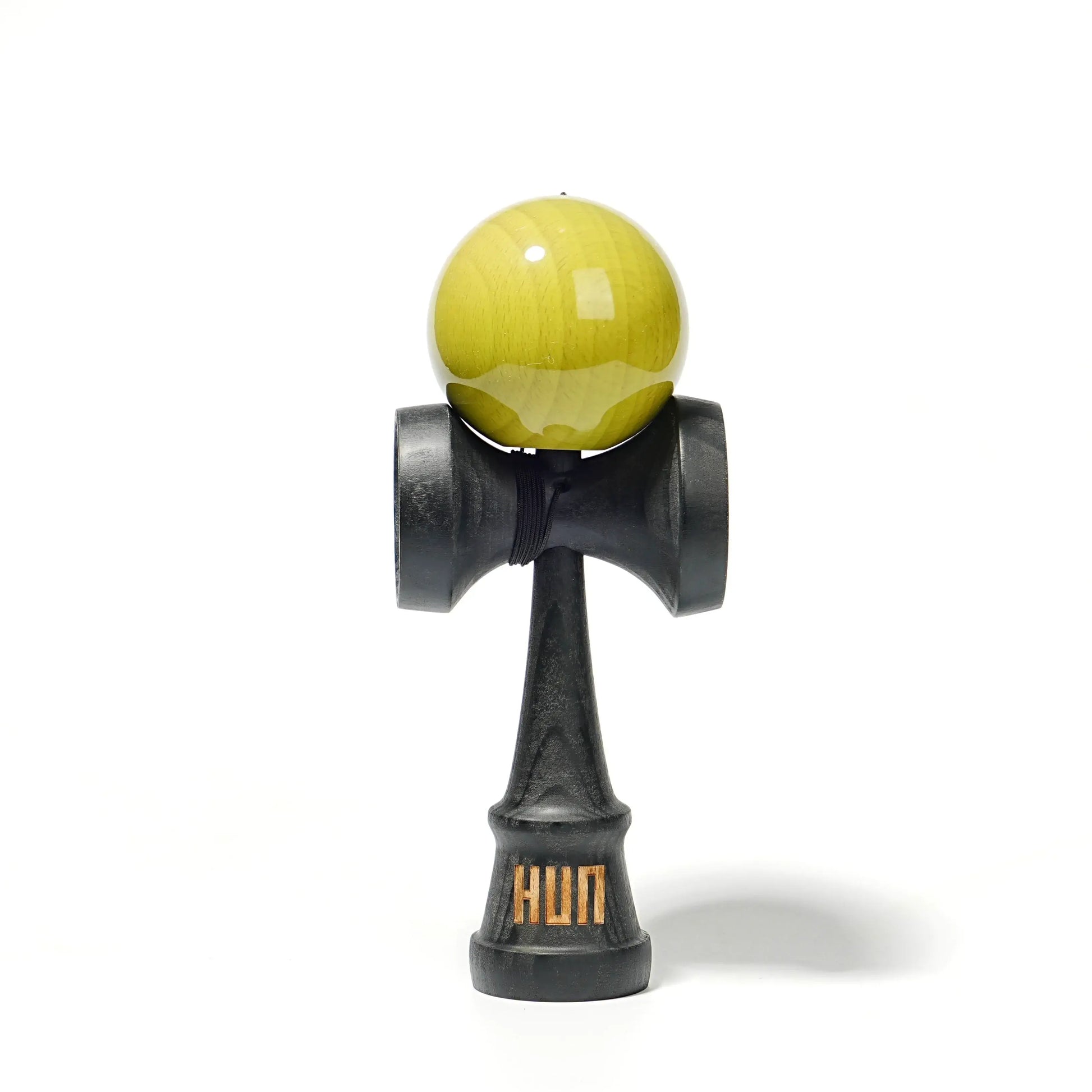 HUN kendama with a glossy yellow ball, black wooden handle, and light gray background.