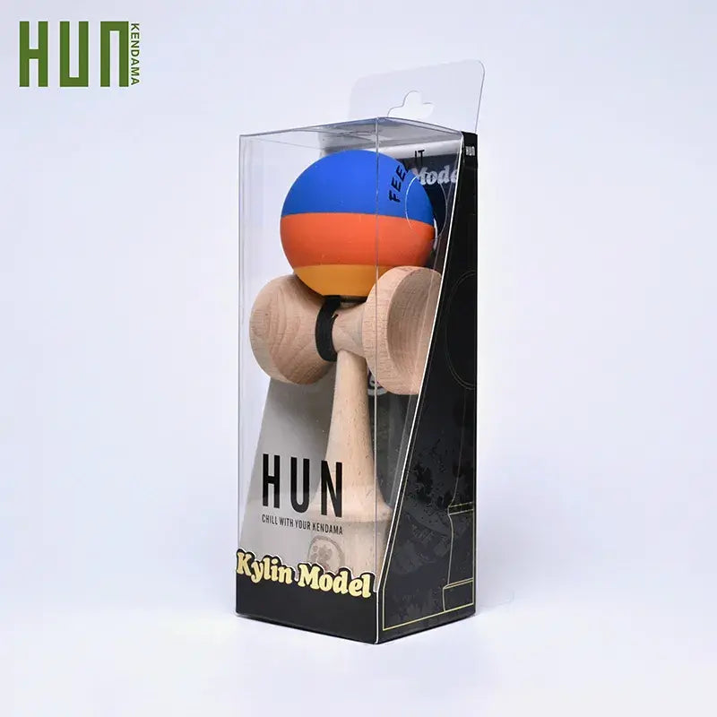 HUN Kendama Kylin Model packaged in a clear retail box, with a wooden kendama and blue, orange, and yellow striped ball on a light background.