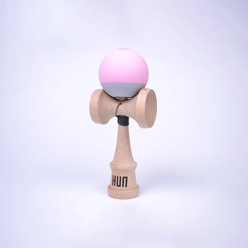 HUN Kendama Kylin Model with a pastel pink and gray ball, natural wood handle, and light background.